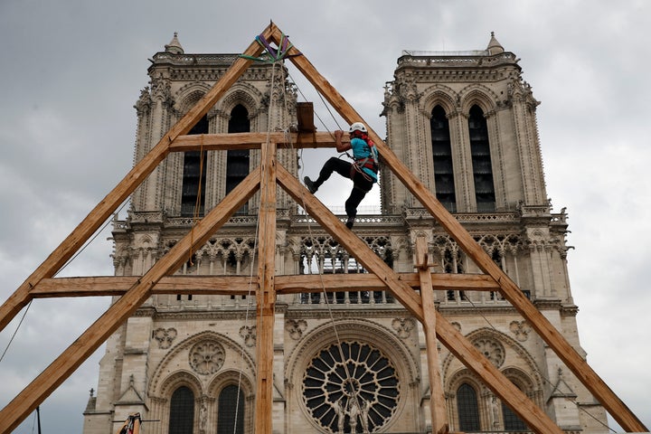 A carpenter works on Notre Dame Cathedral in Paris on Sept. 19, 2020. France's Notre Dame Cathedral's reconstruction is progressing enough to allow its reopening to visitors and masses at the end of next year, less than six years after the after the shocking fire that tore through its roof, French officials said as an exhibit pays tribute to hundreds of artisans working on it. 