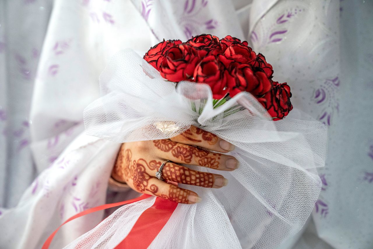 Μια Aφγανή νύφη κρατά ένα μπουκέτο με τριαντάφυλλα σε μια μαζική γαμήλια τελετή, κατά τη διάρκεια της Παγκόσμιας Ημέρας της Γυναίκας στην Καμπούλ του Αφγανιστάν, Τετάρτη 8 Μαρτίου 2023.