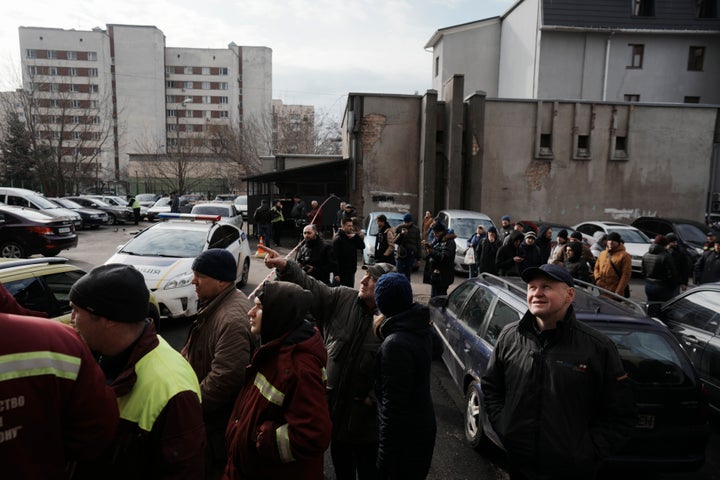 People wait behind police cordon after a rocket attack in Kyiv, Ukraine, on March 9, 2023.