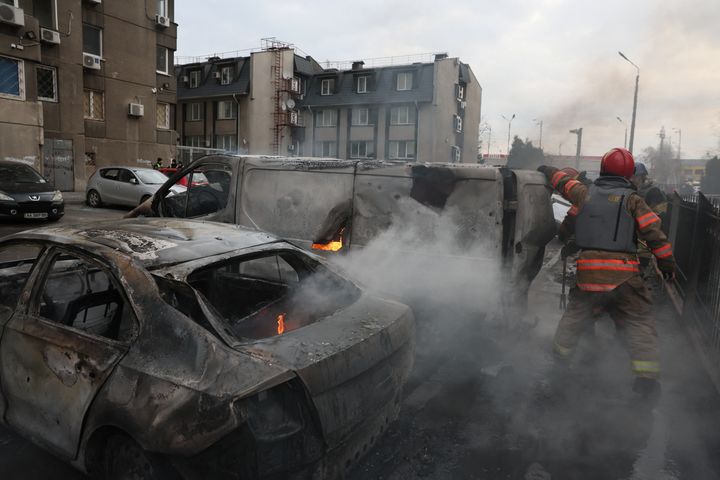 Emergency workers extinguish fire in vehicles at the site of a Russian missile strike, in Kyiv, Ukraine, on March 9, 2023.
