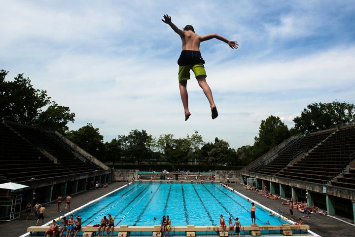 A boy jumps into the water at the Olympic open air public pool in Berlin, Germany, May 21, 2014. Women in Berlin will soon be allowed to go topless at the city's public pools, the Berlin state government said Thursday. The new bathing rules to allow both men and women to go swimming without covering their upper bodies came in reaction to a woman's complaint alleging discrimination because she was not allowed to swim topless in a swimming pool in Berlin, like men. (AP Photo/Markus Schreiber, File)