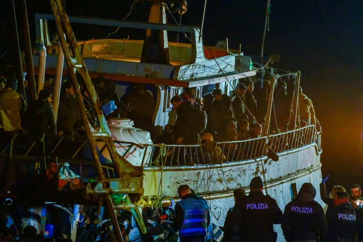 La police contrôle un bateau de pêche avec quelque 500 migrants dans le port de Crotone, dans le sud de l'Italie, tôt le samedi 11 mars 2023. Les garde-côtes italiens répondaient à trois bateaux de passeurs transportant plus de 1 300 migrants 