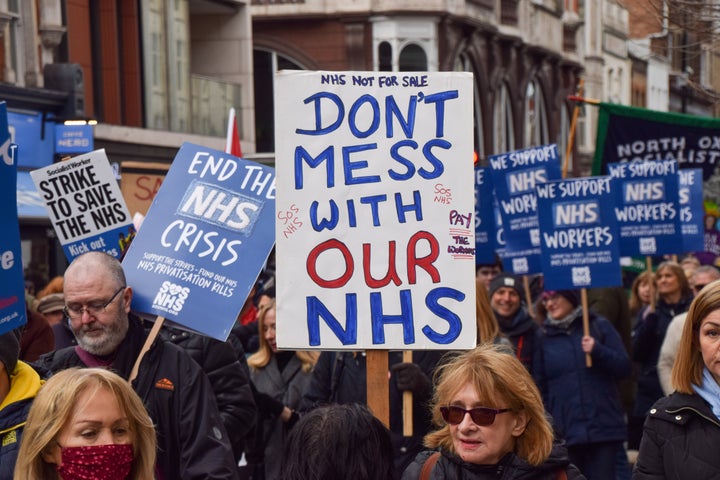 A protester holds a placard which states 'Don't mess with our NHS' during the demonstration in Tottenham Court Road.