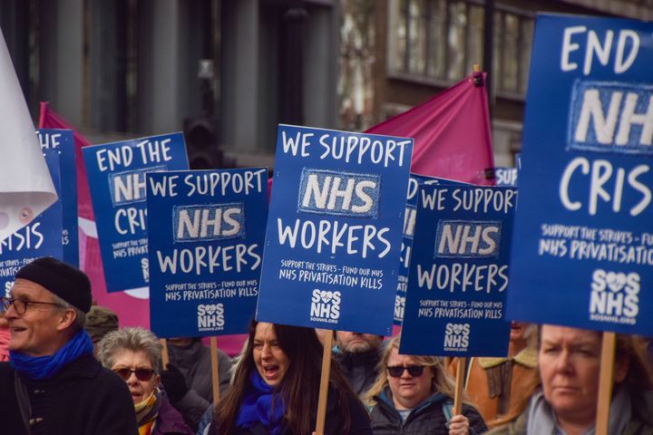 Protesters hold placards in support of NHS workers during the demonstration.