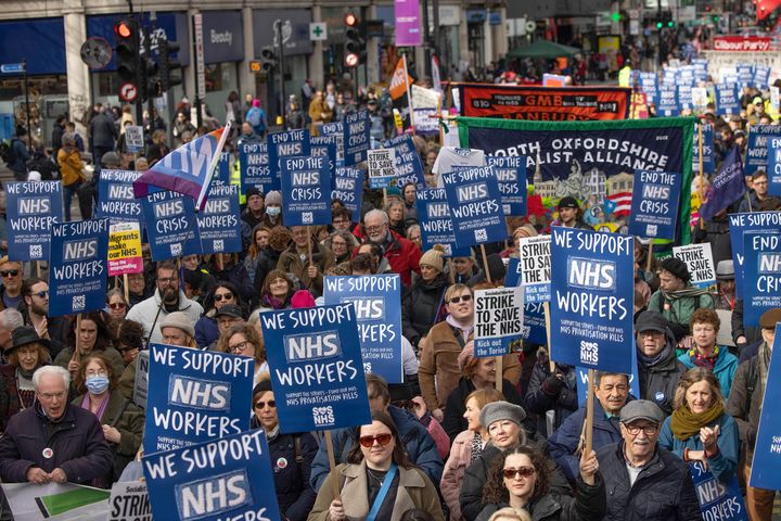 NHS workers including doctors and nurses and their supporter hold placards during the demonstration. 