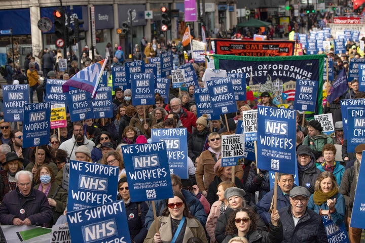 NHS workers including doctors and nurses and their supporter hold placards during the demonstration. 