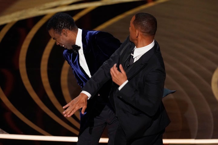 Will Smith, right, hits presenter Chris Rock on stage while presenting the award for best documentary feature at the Oscars on Sunday, March 27, 2022, at the Dolby Theatre in Los Angeles. (AP Photo/Chris Pizzello, File)