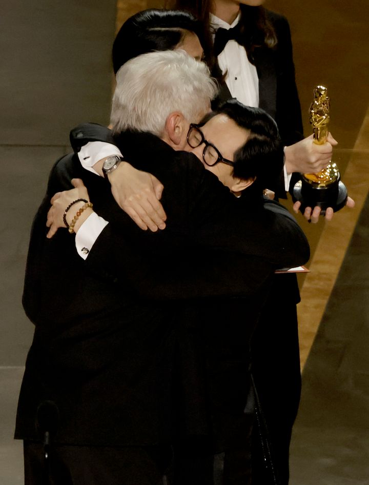 Ke Huy Quan (right) accepts the award for Best Picture for "Everything Everywhere All at Once" from Harrison Ford.