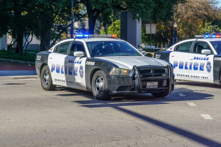 Police car on traffic duty in downtown Dallas. People are pictured in the background