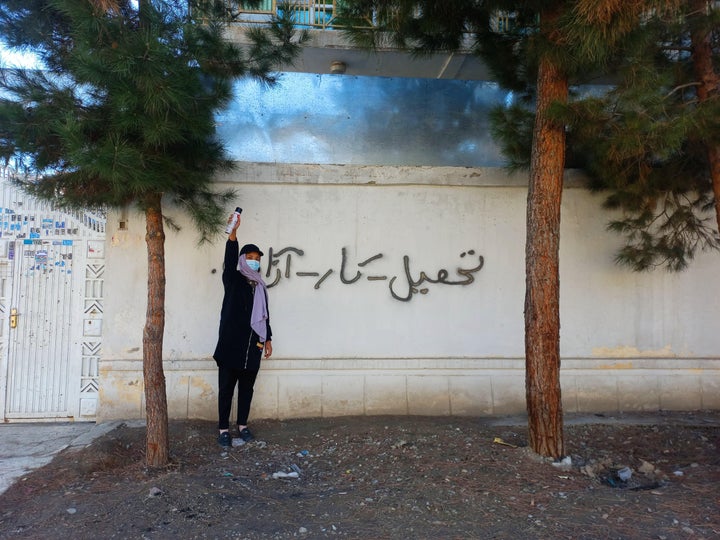 A spray-painted message on the wall reads 