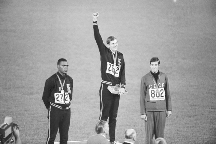 Gold medal winner Dick Fosbury raises his arm as the victor at the 1968 Olympics in Mexico City.