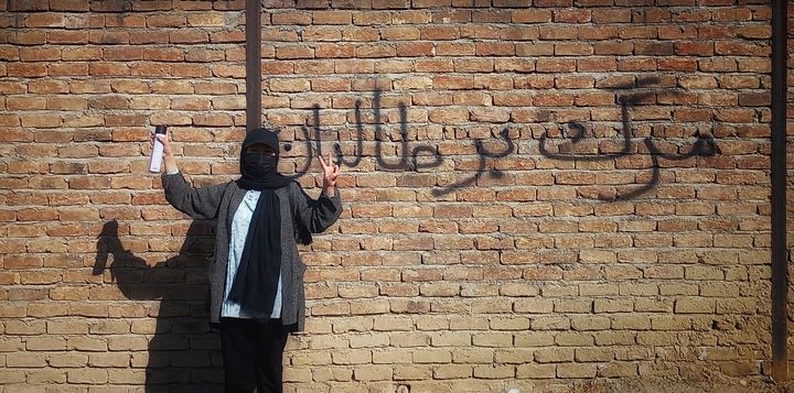 Zahra, an activist for women's rights who spray-paints messages of resistance on the streets of Kabul, Afghanistan. This message reads "Death to Taliban."