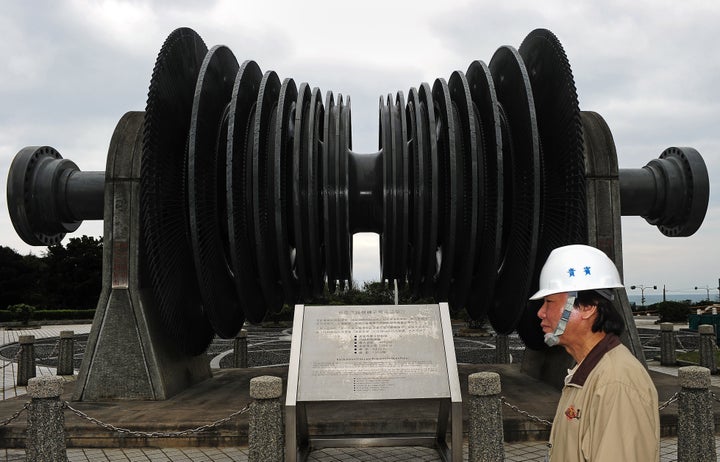 A worker from the state-owned Taiwan Power Co. walks past a retired low-pressure turbine rotor on display at the second nuclear power plant in Wanli, New Taipei City, on Feb. 20, 2012. 