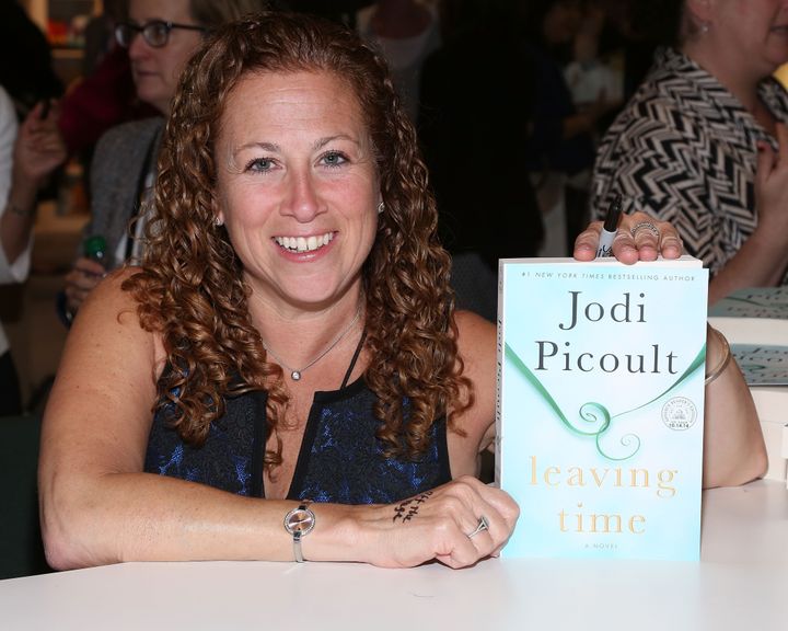Author Jodi Picoult holds up her novel, "Leaving Time" during the 2014 Bookexpo America in New York. Her book was listed as removed from school libraries in Martin County, Florida, following a complaint.
