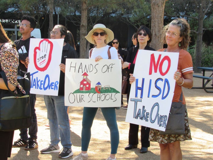 FILE - People hold up signs at a news conference, Friday, March 3, 2023, in Houston while protesting the proposed takeover of the city's school district by the Texas Education Agency. Texas officials on Wednesday, March 15, announced a state takeover of Houston's nearly 200,000-student public school district, the eighth-largest in the country, acting on years of threats and angering Democrats who assailed the move as political. (AP Photo/Juan A. Lozano)