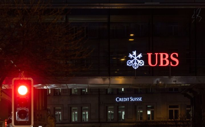ΖΥΡΙΧΗ, ΕΛΒΕΤΙΑ - 16 ΜΑΡΤΙΟΥ: Ένα κόκκινο φανάρι σε δρόμο της Ζυρίχης εμφανίζεται μπροστά από τα λογότυπα των ελβετικών τραπεζών Credit Suisse και UBS την ημέρα μετά την πτώση των μετοχών της πρώτης κατά περίπου 30% στις 16 Μαρτίου 2023 στη Ζυρίχη της Ελβετίας. Η Credit Suisse φέρεται να ζήτησε από την ελβετική κυβέρνηση υποστήριξη μετά την άρνηση ενός Σαουδάραβα μεγαλομετόχου να παράσχει περισσότερη ρευστότητα. Η απότομη πτώση της τιμής της μετοχής οδήγησε σε πτώση τις μετοχές και άλλων μεγάλων ευρωπαϊκών τραπεζών. Η αναστάτωση έρχεται μετά τη βαθιά κρίση της Silicon Valley Bank στις ΗΠΑ.(Photo by Arnd Wiegmann/Getty Images)