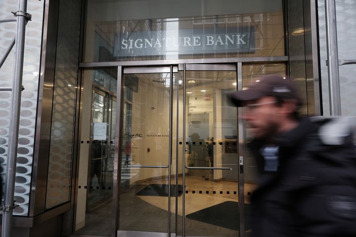 People walk by a Manhattan branch of Signature Bank that was closed by bank regulators on March 13. The move by the state's Department of Financial Services sought to prevent a banking crisis spurred by the failure of Silicon Valley Bank.