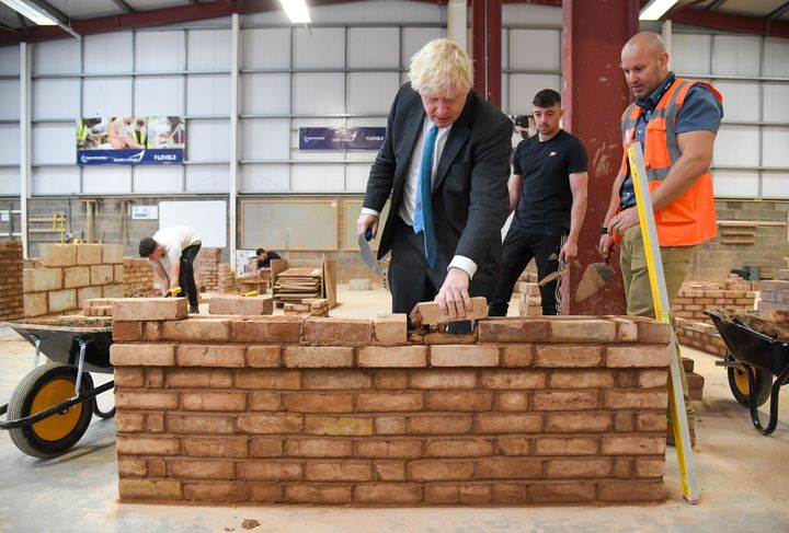 Former Prime Minister Boris Johnson lays a brick.