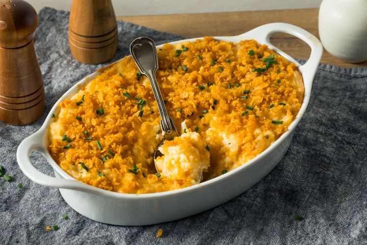 A homemade funeral potatoes casserole with cheese and chives.