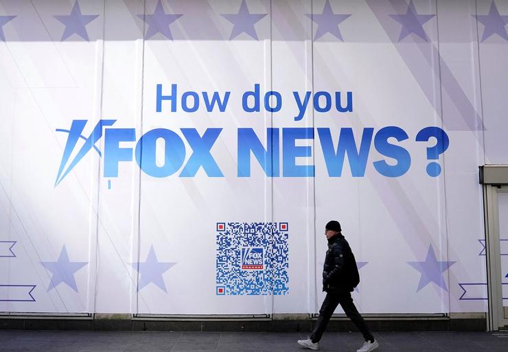 A person walks past the Fox News Headquarters at the News Corporation building in New York City on March 9. Dominion Voting Systems is suing Fox News and parent company Fox Corp. over election fraud claims.
