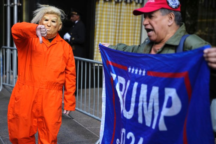 Mike Hisey, dressed to portray former President Trump in a prison uniform, gestures toward Mariano Laboy, a Trump supporter, outside Trump Tower on Tuesday.