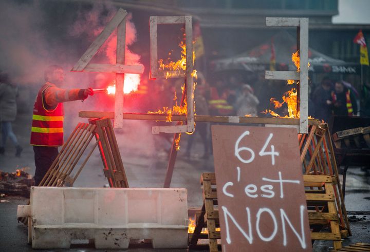 フランスで大規模なストライキが行われている中、火を放つデモ参加者。