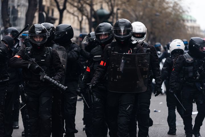 Riot police stand in the middle of the crowd during clashes with demonstrators on Thursday