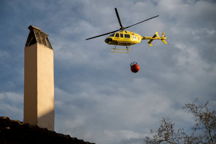 A helicopter with a bucket of water to extinguish the forest fire that originated in Villanueva de Viver.