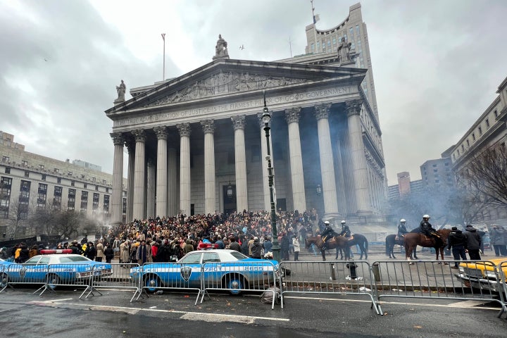 Throngs of actors portraying protesters, some in make-up, gather outside a courthouse in New York on Saturday. Production crews had to wrestle with the possibility that filming could be disrupted by real-life protests over the Trump case, none of which have materialized so far.