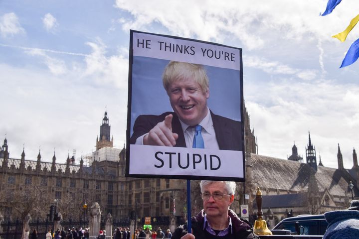 A protester holds an anti-Boris Johnson placard during the demonstration. 