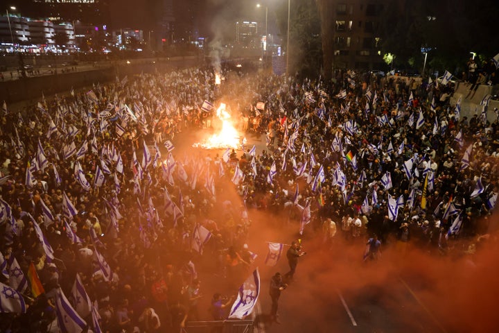 Israelis opposed to Prime Minister Benjamin Netanyahu's judicial overhaul plan set up bonfires and block a highway during a protest moments after the Israeli leader fired his defense minister, in Tel Aviv, Israel, Sunday, March 26, 2023. Defense Minister Yoav Gallant had called on Netanyahu to freeze the plan, citing deep divisions in the country and turmoil in the military.