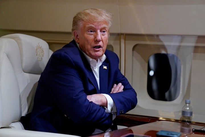 Former President Donald Trump speaks with reporters while in flight on his plane after a campaign rally in Waco, Texas on Saturday.