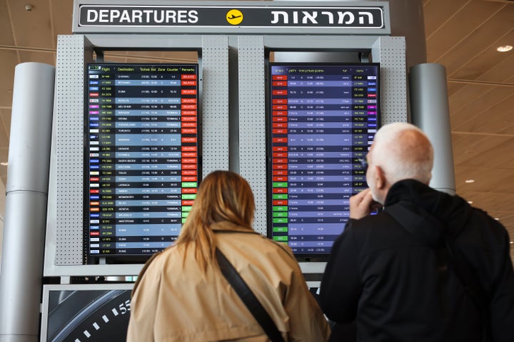 Passengers look at the monitor displaying delayed flights at Ben Gurion airport, near Tel Aviv, Israel, on Monday.