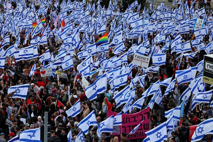 Les manifestants se rassemblent avec des drapeaux nationaux devant le parlement israélien à Jérusalem lundi au milieu des manifestations en cours et des appels à une grève générale contre les efforts du gouvernement d'extrême droite pour remanier le système judiciaire.