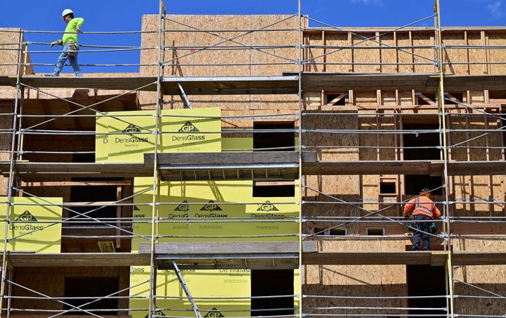 Construction workers walk on scaffolding around a new block of apartments in Los Angeles, California, on Aug. 16, 2022.