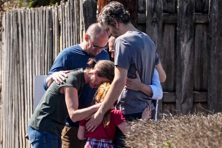 A group prays with children outside a reunification center at Woodmont Baptist Church in Nashville after the shooting.