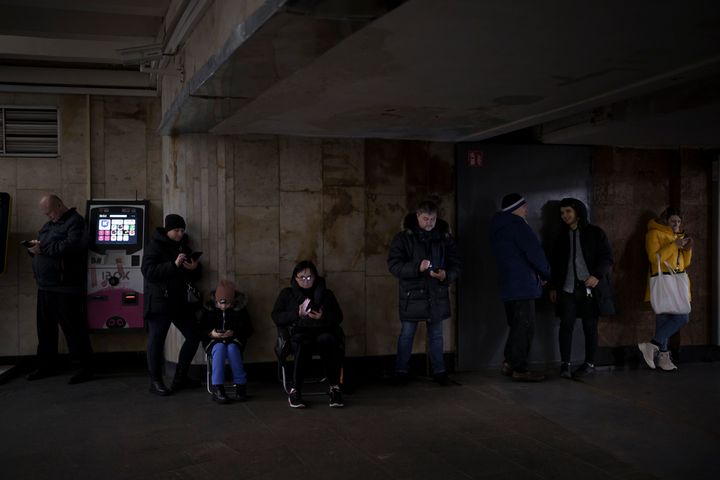Κάτοικοι του Κέβου χρησιμοποιούν τα τηλέφωνά τους ενώ συγκεντρώνονται σε έναν σταθμό του μετρό κατά τη διάρκεια συναγερμού αεροπορικής επιδρομής, στο Κίεβο, Ουκρανία, Τετάρτη, 21 Δεκεμβρίου 2022.