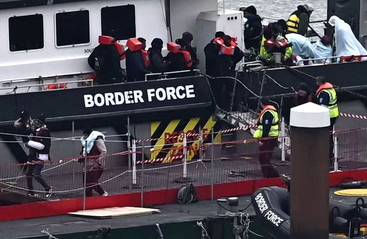 Migrants are escorted ashore from the UK Border Force vessel are being picked up in the English Channel