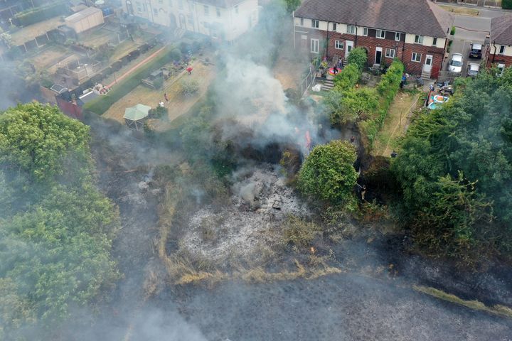 In this aerial view Firefighters contain a wildfire that encroached on nearby homes in Sheffield on July 20, 2022 during a heatwave