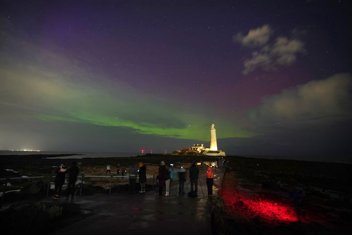 The aurora borealis, also known as the northern lights, glow on the horizon at St Mary's Lighthouse in Whitley Bay on the North East coast, March 23, 2023.