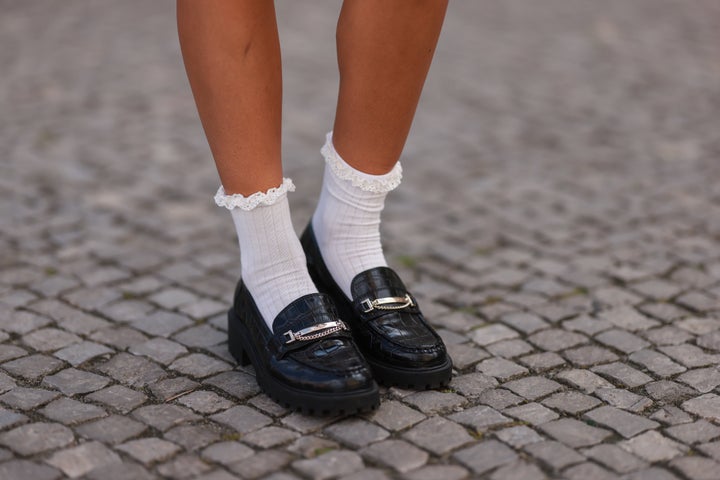 A woman is seen wearing white socks and black Aldo loafers in Berlin in 2022.