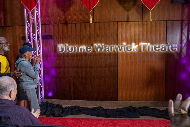 Dionne Warwick claps as her name is unveiled at Bowie State University's performing arts venue.