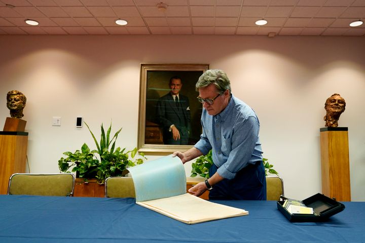 Peter Mangan flips through a large folder of newspaper clippings at the Lyndon B. Johnson's presidential library as he prepares to make a donation to the library, Wednesday, Aug. 31, 2022, in Austin, Texas. The family of the late Associated Press reporter James W. Mangan has donated to the library cassette tapes containing interviews the reporter did that led to a 1977 story in which a Texas voting official detailed how three decades earlier, votes were falsified to give Johnson a slim victory in a U.S. Senate primary. (AP Photo/Eric Gay)
