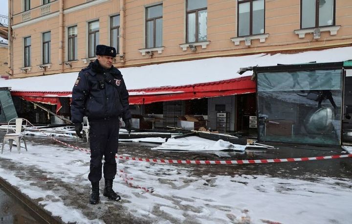 A police officer stands guard at the scene of the cafe explosion in which Russian military blogger Vladlen Tatarsky.