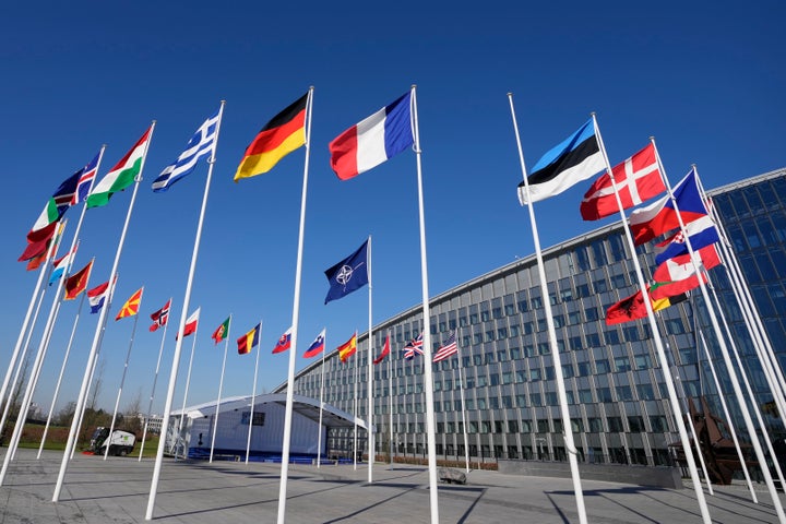 An empty flagpole stands between the national flags of France and Estonia outside NATO headquarters in Brussels, on April 3, 2023.