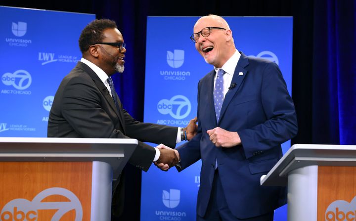 Brandon Johnson, left, and Paul Vallas share a light moment before the start of a televised debate on March 16.