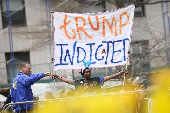 A member of the city police department asks a protester to leave an area near the courthouse where former President Donald Trump is scheduled to be arraigned Tuesday in New York City.