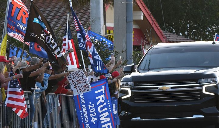 Supporters of former U.S. President Donald Trump wave signs and flags as the motorcade carrying Trump makes its way back to his Mar-a-Lago Club following his arraignment in New York on April 4, 2023, in West Palm Beach, Florida.