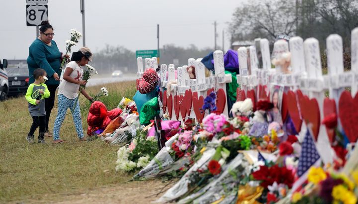 FILE - Christina Osborn and her children Alexander Osborn and Bella Araiza visit a makeshift memorial for the victims of the shooting at Sutherland Springs Baptist Church, Nov. 12, 2017, in Sutherland Springs, Texas. The Justice Department said Wednesday, April 5, 2023, that it has tentatively settled a lawsuit over the 2017 mass shooting at a Texas church that will pay victims and their families more than $144 million. (AP Photo/Eric Gay, File)