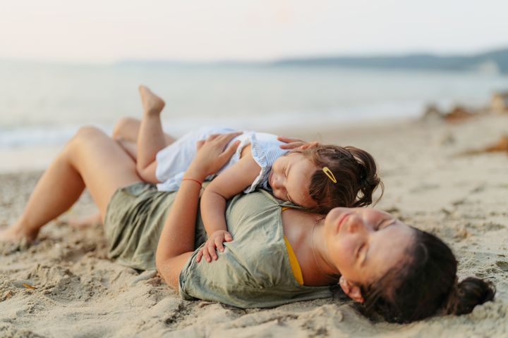 Photo of a single mother on vacation with her two year old girl, enjoy summer breeze, sound of the waves and each other's company